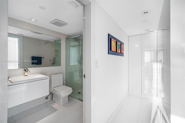 bathroom featuring tile patterned flooring, vanity, a shower with door, and toilet