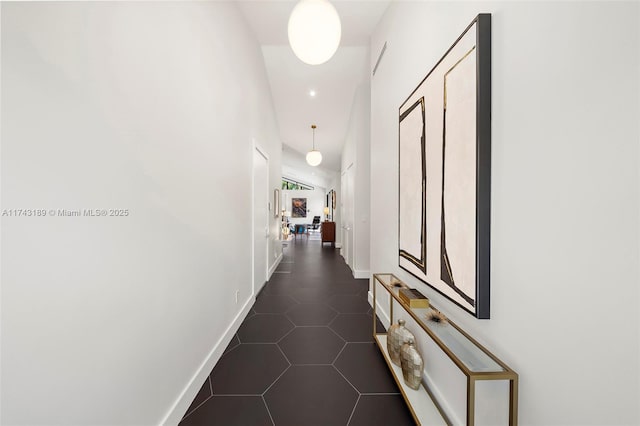 hall featuring dark tile patterned flooring