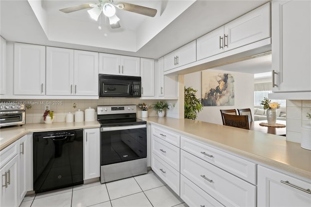 kitchen featuring tasteful backsplash, black appliances, a tray ceiling, kitchen peninsula, and white cabinets