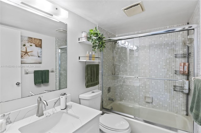 full bathroom featuring enclosed tub / shower combo, vanity, and toilet