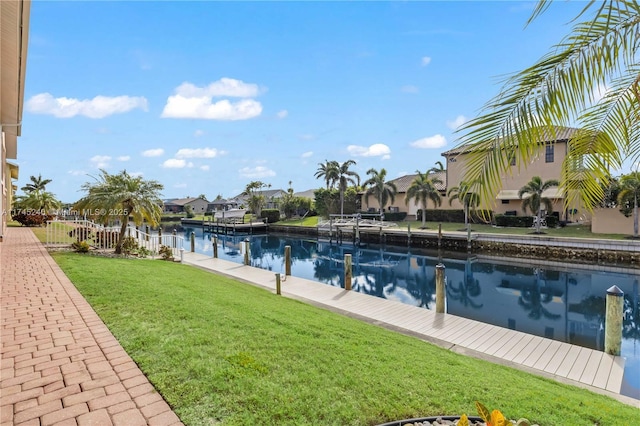 exterior space featuring a water view, a boat dock, and a lawn