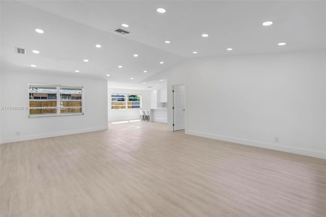 unfurnished living room featuring lofted ceiling and light wood-type flooring