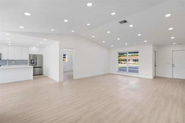 unfurnished living room featuring light hardwood / wood-style flooring and vaulted ceiling