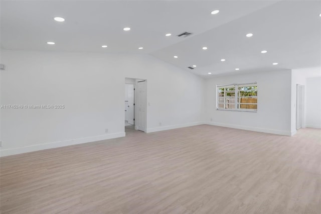 unfurnished room with lofted ceiling and light wood-type flooring