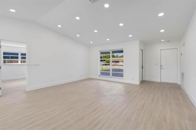 unfurnished living room featuring lofted ceiling and light wood-type flooring