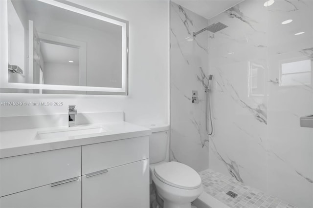 bathroom featuring vanity, toilet, and tiled shower