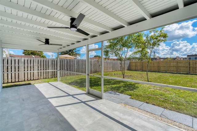 unfurnished sunroom featuring beam ceiling and ceiling fan