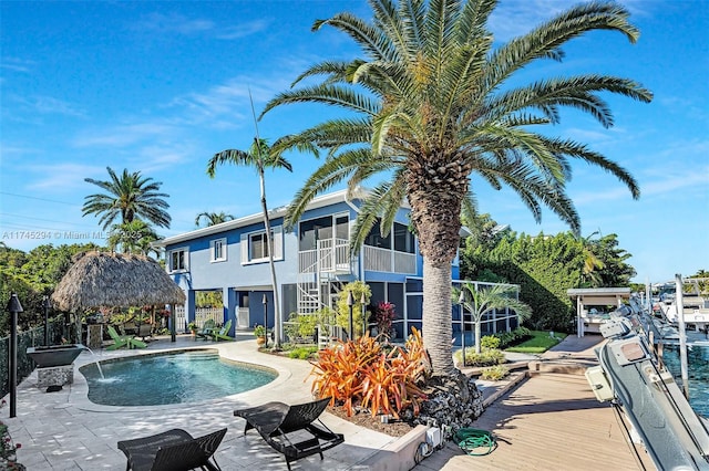 view of pool featuring a gazebo, a patio area, a sunroom, and pool water feature