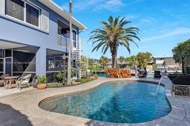 view of swimming pool featuring pool water feature and a patio