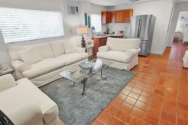 living room featuring sink, tile patterned floors, and an AC wall unit