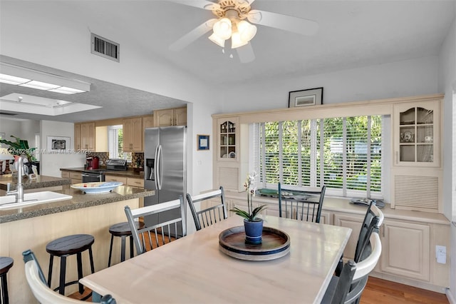 dining area featuring sink, ceiling fan, and light wood-type flooring