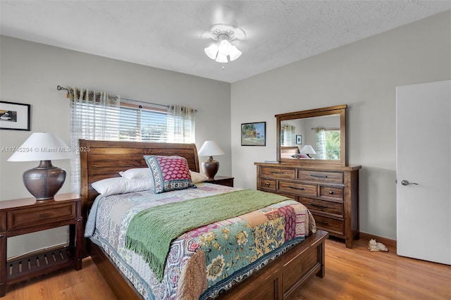 bedroom with light hardwood / wood-style floors and a textured ceiling