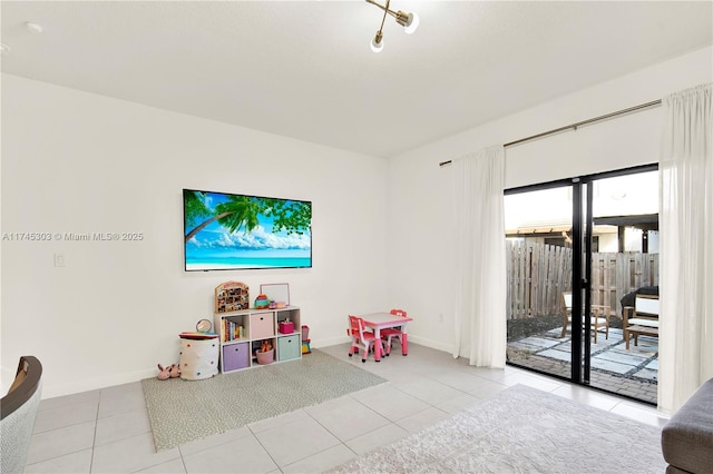 recreation room with baseboards and tile patterned flooring