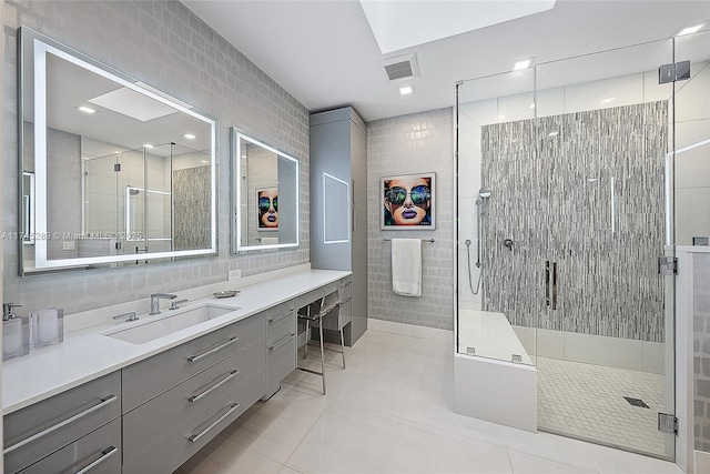 bathroom with walk in shower, vanity, and tile walls