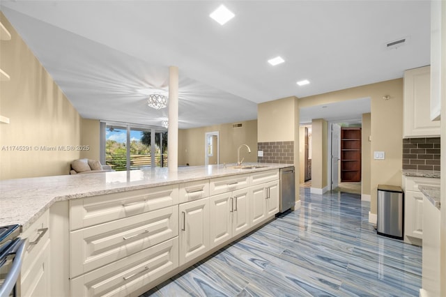 kitchen with light stone counters, sink, white cabinetry, and stainless steel appliances