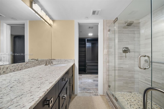 bathroom with walk in shower and vanity