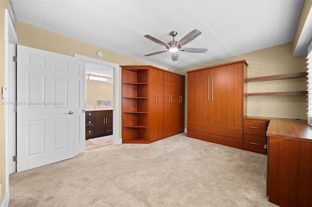 unfurnished bedroom with ceiling fan, light colored carpet, and ensuite bath