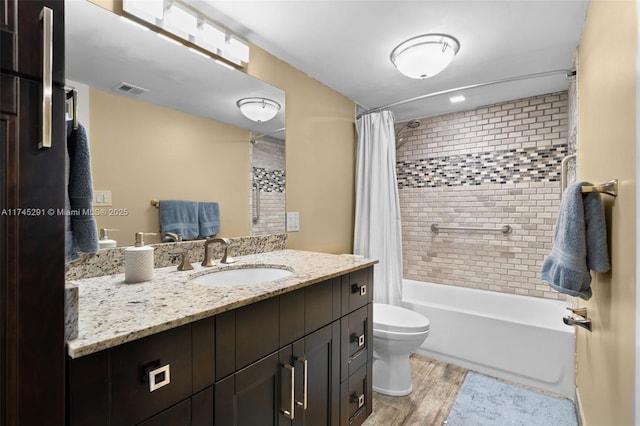 full bathroom featuring hardwood / wood-style flooring, vanity, toilet, and shower / bath combo with shower curtain