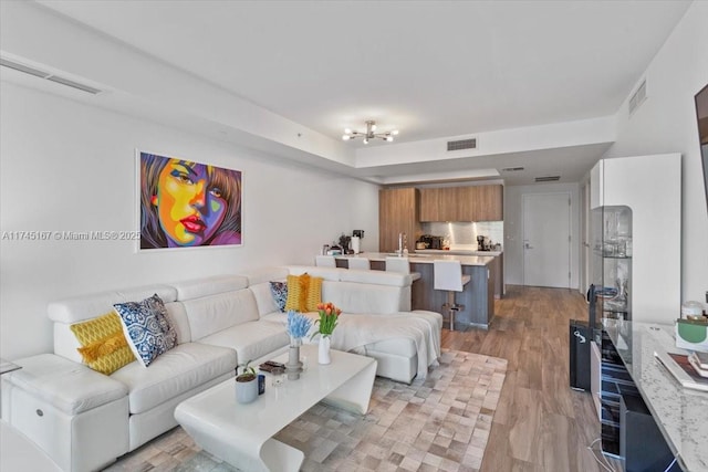 living room with visible vents and light wood-type flooring