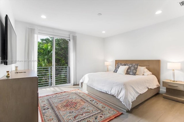 bedroom featuring access to exterior and light wood-type flooring