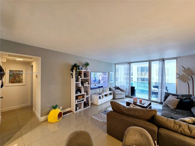 living room with light tile patterned floors, baseboards, and a wall of windows