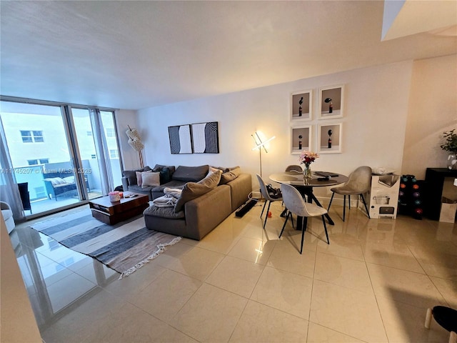 living room with a wall of windows and light tile patterned flooring