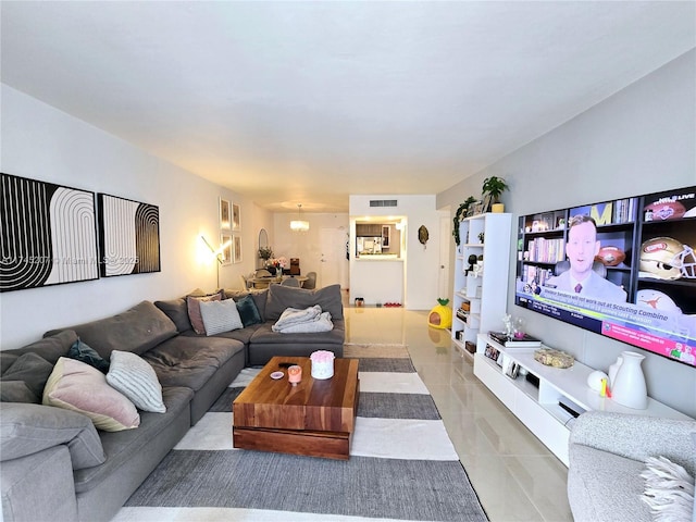 living area featuring light tile patterned floors, visible vents, and an inviting chandelier