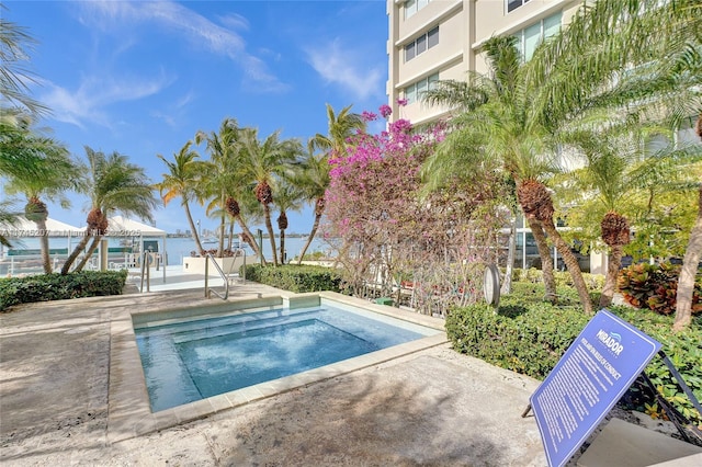 view of pool with a water view and a patio