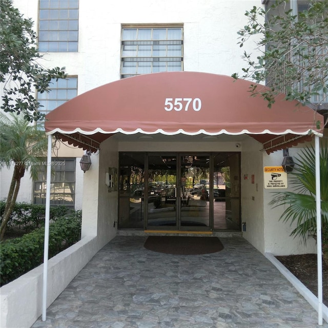 view of exterior entry with french doors and stucco siding