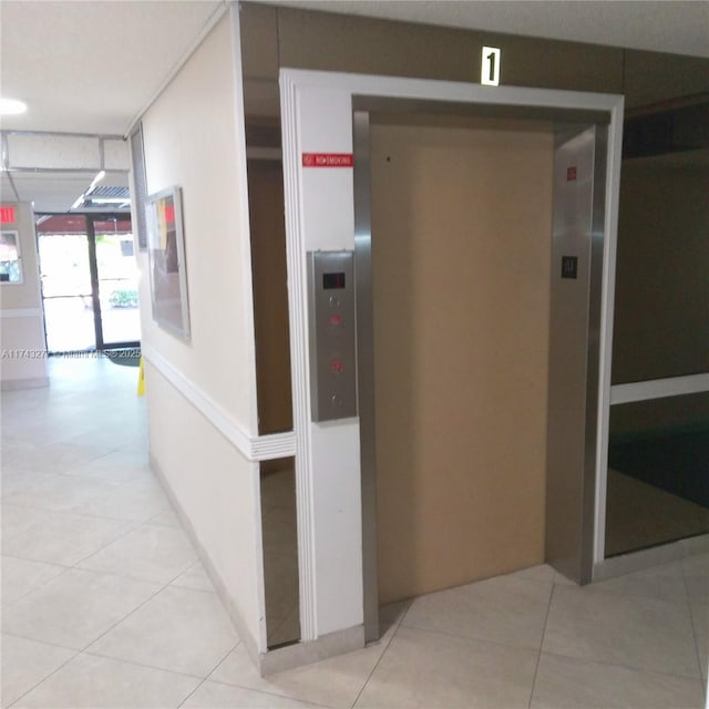 hallway featuring elevator and tile patterned flooring