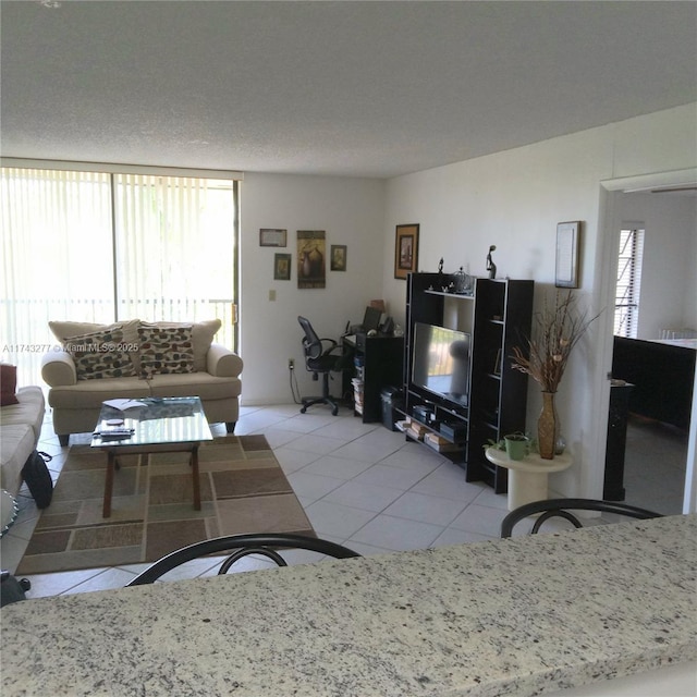 living area featuring plenty of natural light, a textured ceiling, and light tile patterned flooring