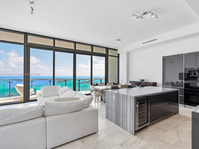 1451 Brickell Ave Unit 5101, Miami, FL 33131 - living area with beverage cooler, expansive windows, track lighting, a water view, and light marble finish floors