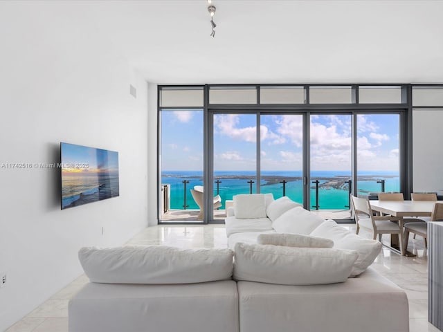 living room featuring a wall of windows, track lighting, and plenty of natural light