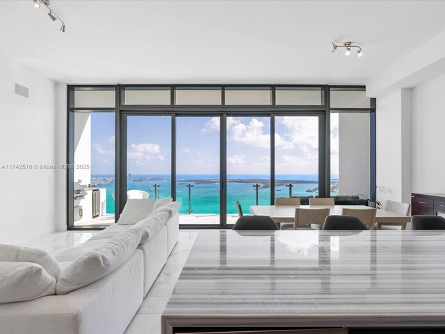 1451 Brickell Ave Unit 5101, Miami, FL 33131 - living area with track lighting, a water view, expansive windows, and healthy amount of natural light