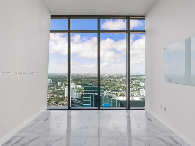 1451 Brickell Ave Unit 5101, Miami, FL 33131 - empty room featuring expansive windows, healthy amount of natural light, a city view, and marble finish flooring