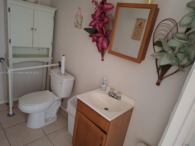 half bath featuring tile patterned flooring, vanity, and toilet