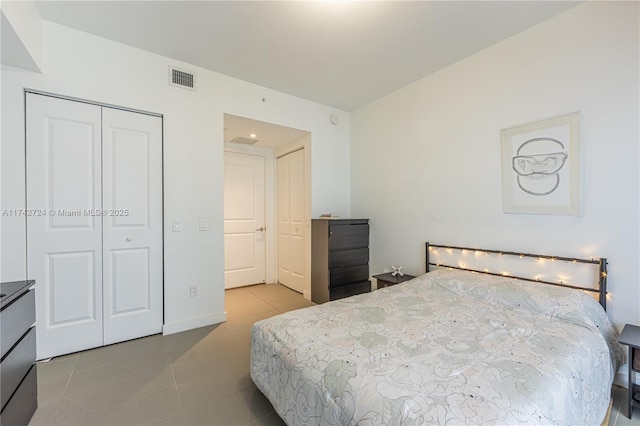 bedroom with a closet and light tile patterned flooring