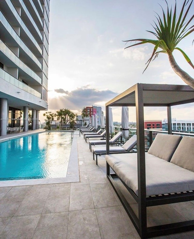 pool at dusk with a patio area