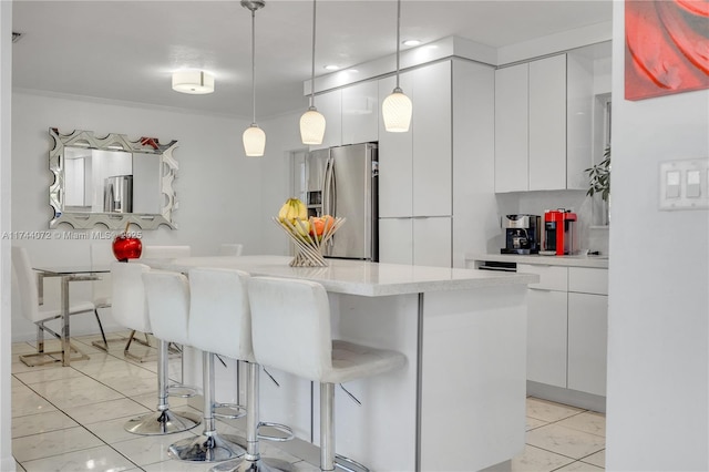 kitchen featuring white cabinetry, pendant lighting, a kitchen bar, and stainless steel fridge with ice dispenser