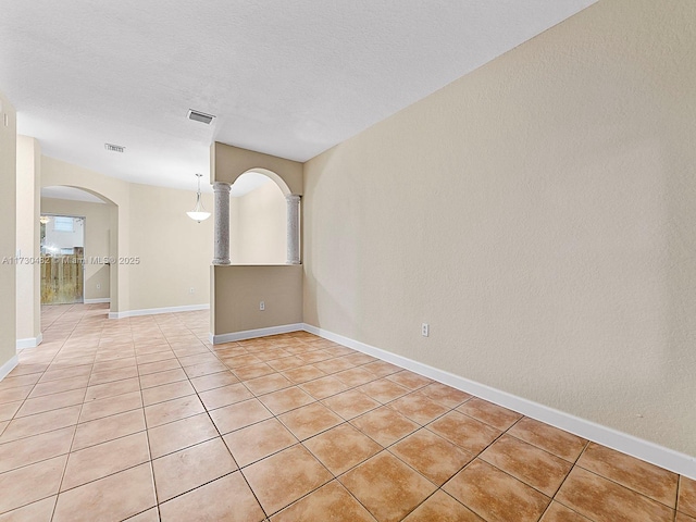 tiled spare room featuring a textured ceiling