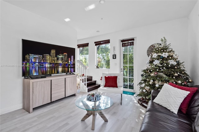 living area featuring baseboards, wood finished floors, and stairs