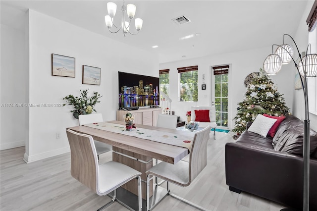 dining space featuring a chandelier, visible vents, light wood-type flooring, and baseboards