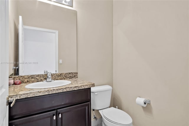 half bath featuring toilet and vanity