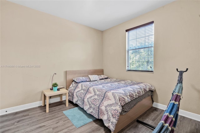 bedroom with wood finished floors and baseboards