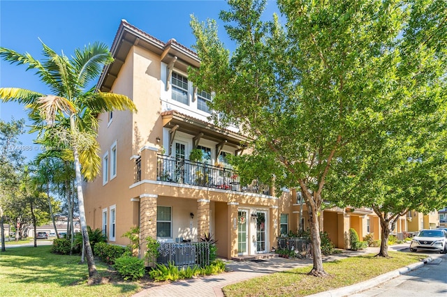 townhome / multi-family property featuring a front lawn