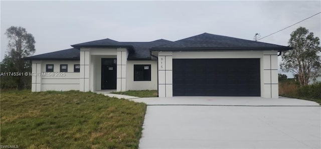 prairie-style home featuring a garage and a front lawn