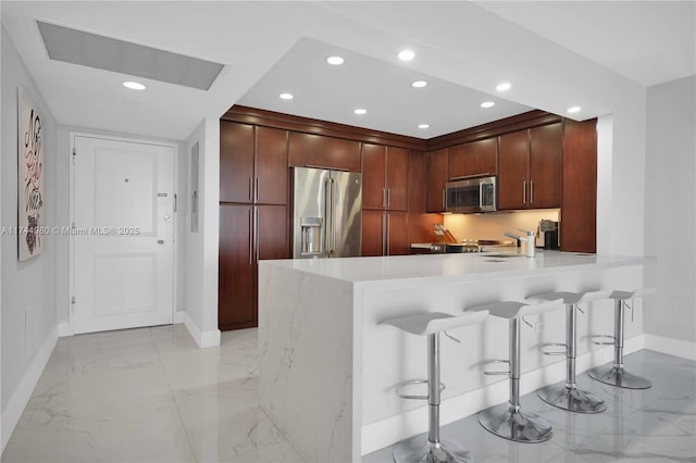 kitchen featuring a kitchen breakfast bar, kitchen peninsula, and appliances with stainless steel finishes