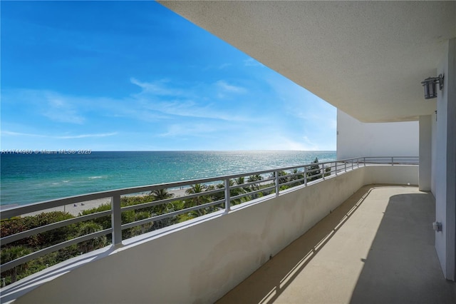 balcony featuring a water view and a beach view