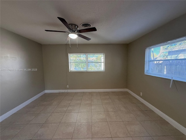 tiled spare room with ceiling fan and a textured ceiling