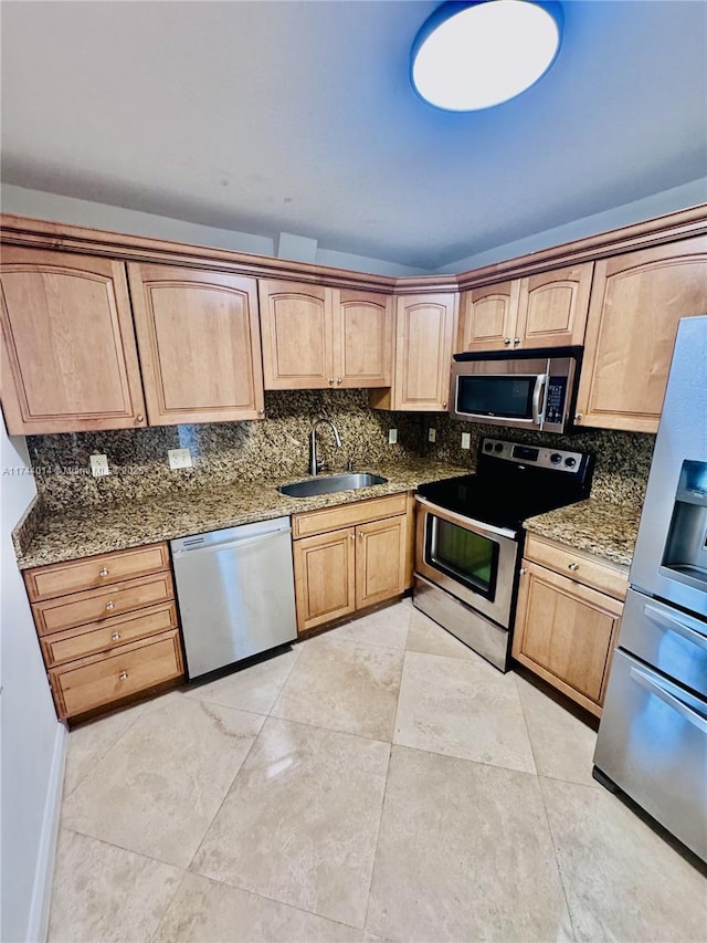 kitchen featuring stainless steel appliances, tasteful backsplash, sink, and dark stone counters